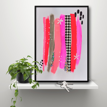 Muurkunst rood roze en pied de poule. Abstracte gekleurde banen in A3 formaat in rood, roze en zwart wit. Sfeerbeeld van ingelijst kunstwerk op een plank met plantje.