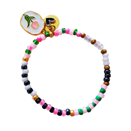 Armband kralen met elastiek in groen, roze, wit, zwart en goudtinten. Met drie bedels waarvan één met een roze tulp.