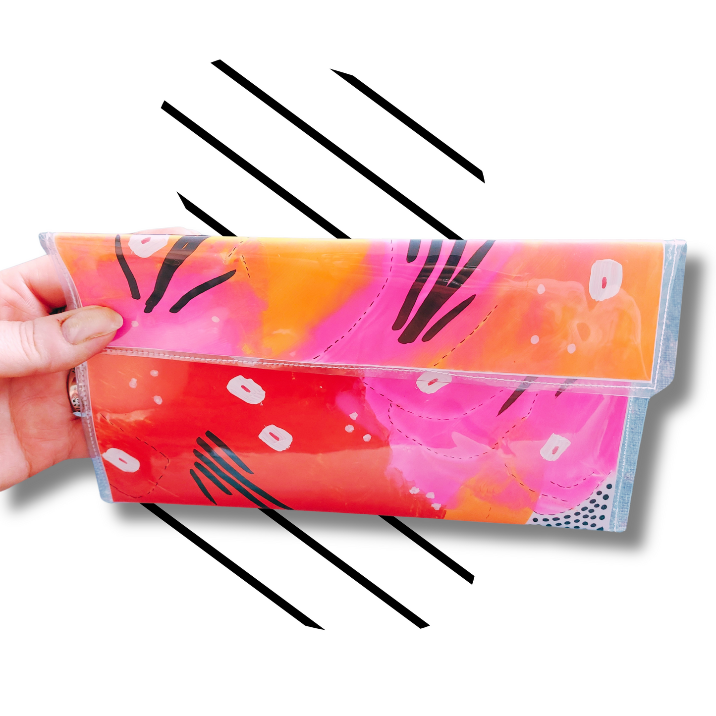 Handtas clutch in rode, roze en oranje kluren met zwart witte accenten, sfeerbeeld